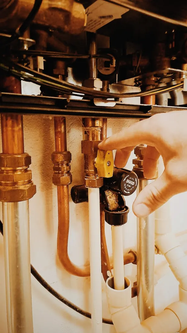 Monteur draait de gaskraan onder de cv-ketel dicht